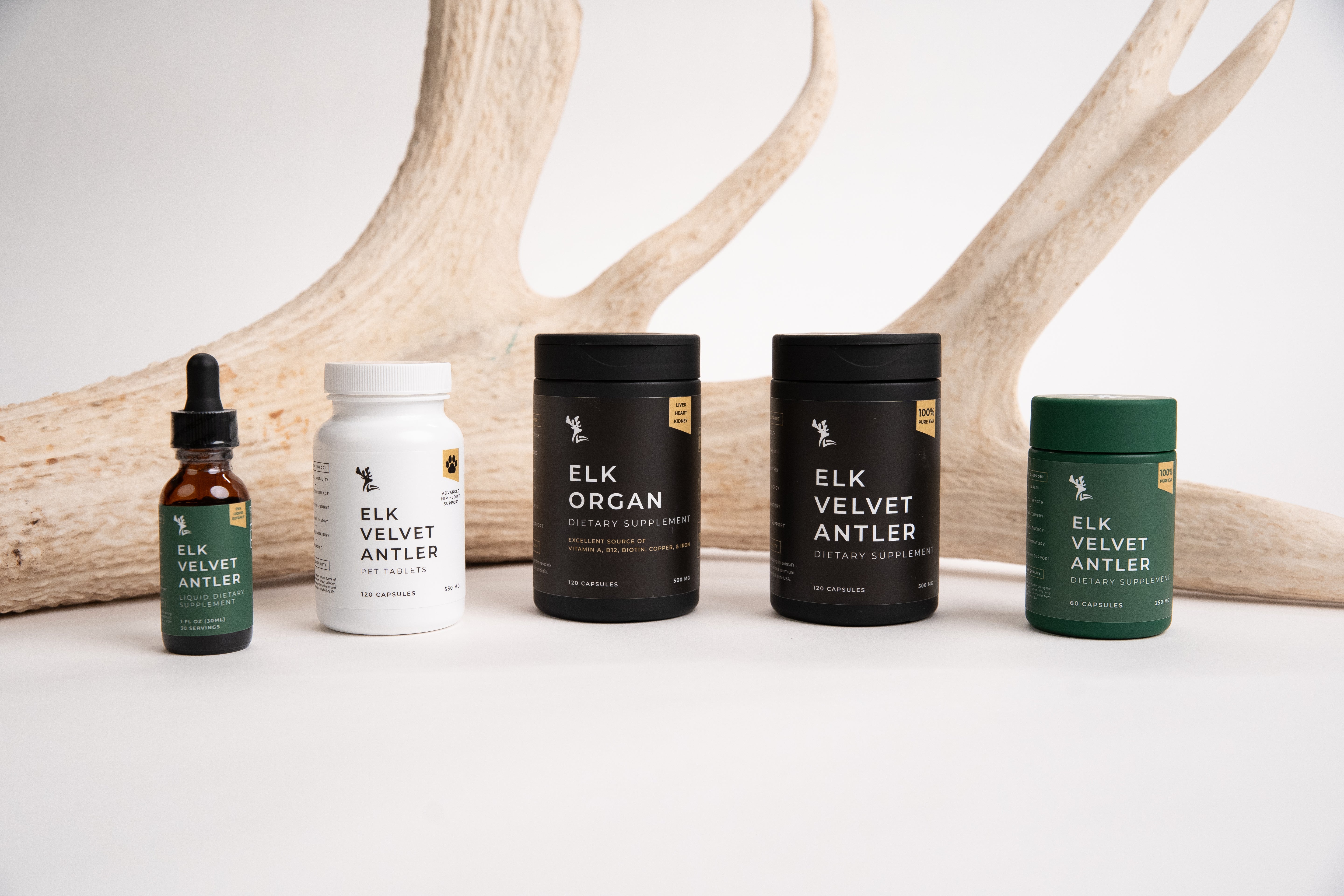 Collection of Cervid Labs Velvet Elk products including a various bottles, on a white surface with antlers in the background.