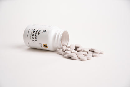 White supplement bottle with pills on a white background