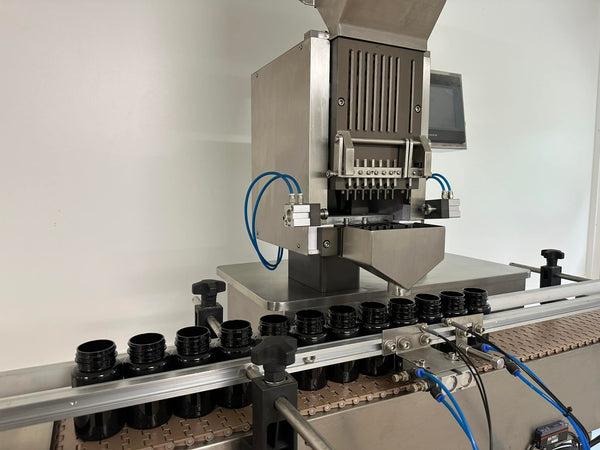 Automated machine with bottles on a conveyor belt in a factory setting